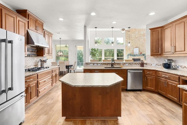 174 Jayne Cv, Austin, TX 78737 - kitchen featuring stainless steel appliances, under cabinet range hood, backsplash, a center island, and brown cabinetry