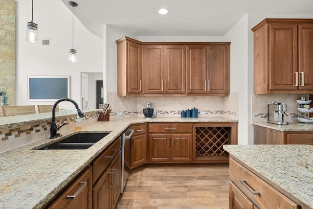 174 Jayne Cv, Austin, TX 78737 - kitchen featuring light stone countertops, light wood-style flooring, backsplash, pendant lighting, and recessed lighting