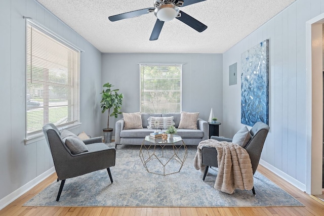 932 E 53 1/2 St, Austin, TX 78751 - living area featuring wood finished floors, a textured ceiling, ceiling fan, and electric panel