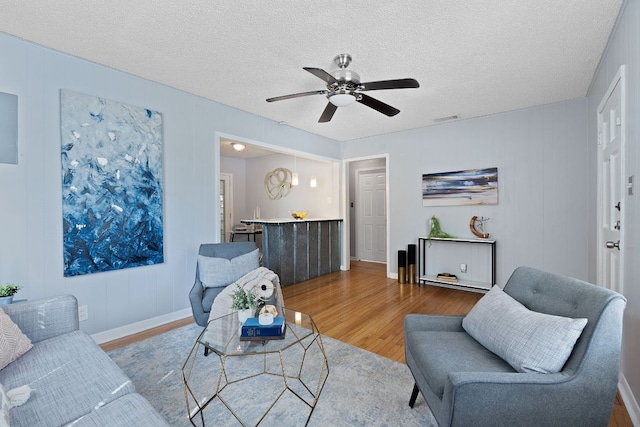 932 E 53 1/2 St, Austin, TX 78751 - living room featuring wood finished floors, ceiling fan, and a textured ceiling
