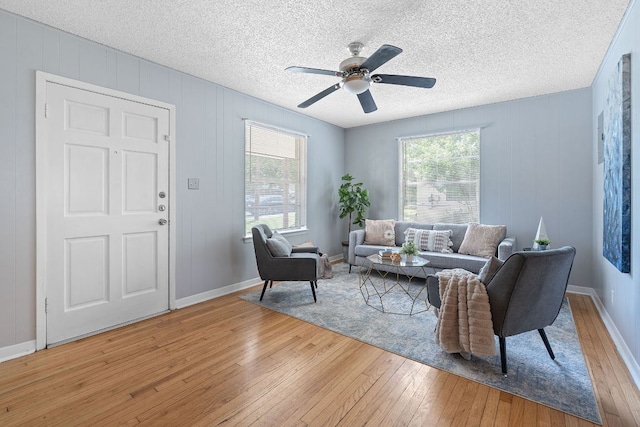 932 E 53 1/2 St, Austin, TX 78751 - living area featuring light wood finished floors, healthy amount of natural light, ceiling fan, and a textured ceiling