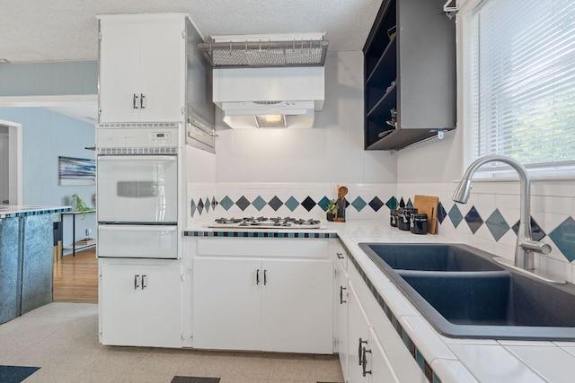 932 E 53 1/2 St, Austin, TX 78751 - kitchen featuring white appliances, a warming drawer, white cabinetry, light countertops, and a textured ceiling