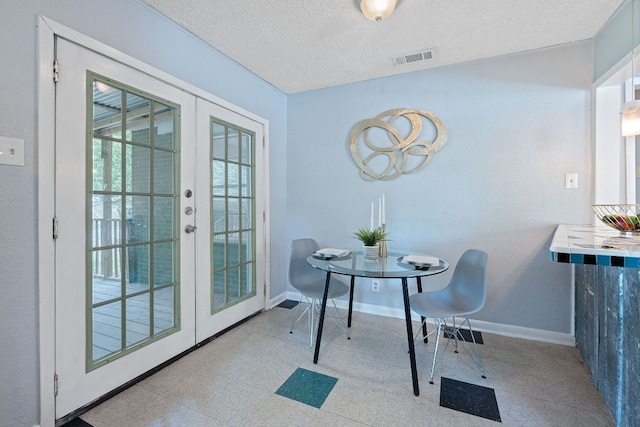 932 E 53 1/2 St, Austin, TX 78751 - dining space with french doors, a textured ceiling, and tile patterned floors