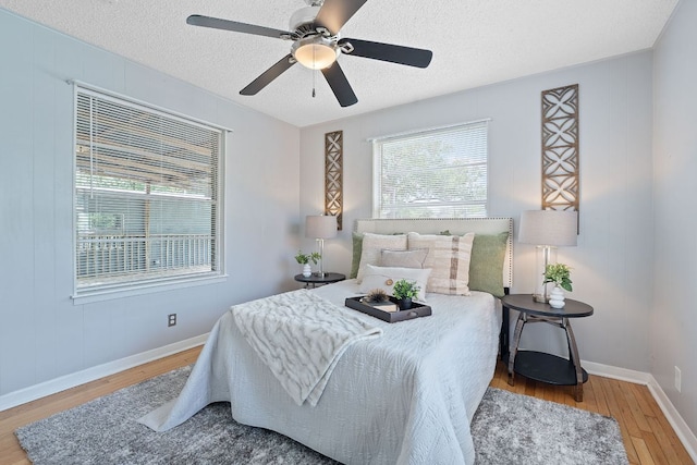932 E 53 1/2 St, Austin, TX 78751 - bedroom featuring wood finished floors, a textured ceiling, and ceiling fan
