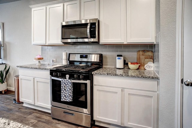 508 Bluffview Dr, Bastrop, TX 78602 - kitchen featuring appliances with stainless steel finishes, dark wood-style floors, backsplash, white cabinetry, and light stone countertops