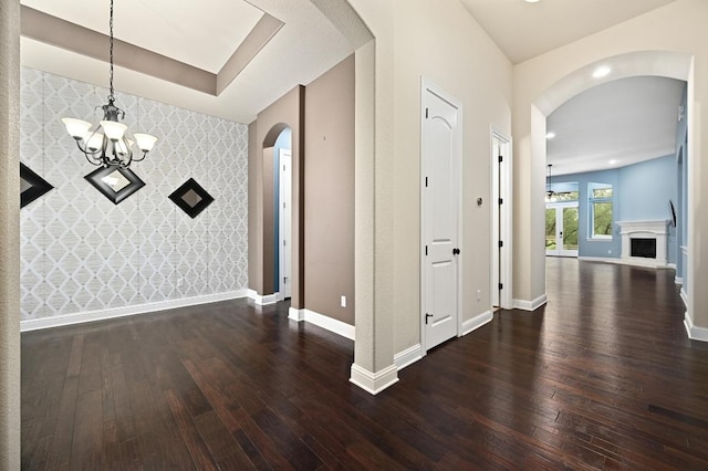204 Lake Como Dr, Austin, TX 78734 - unfurnished dining area with wallpapered walls, an accent wall, arched walkways, wood-type flooring, and a chandelier