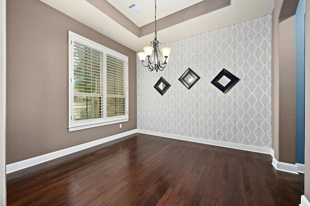 204 Lake Como Dr, Austin, TX 78734 - unfurnished dining area with a chandelier, dark wood-type flooring, a tray ceiling, wallpapered walls, and an accent wall