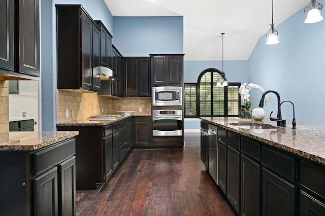 204 Lake Como Dr, Austin, TX 78734 - kitchen featuring appliances with stainless steel finishes, light stone counters, backsplash, dark wood-style floors, and lofted ceiling