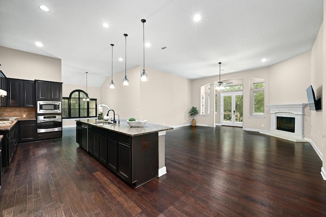 204 Lake Como Dr, Austin, TX 78734 - kitchen with appliances with stainless steel finishes, open floor plan, dark wood-type flooring, ceiling fan, and light stone countertops
