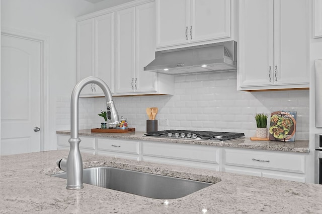 4409 Arques Ave, Round Rock, TX 78681 - kitchen featuring ventilation hood, white cabinets, stainless steel gas stovetop, and backsplash