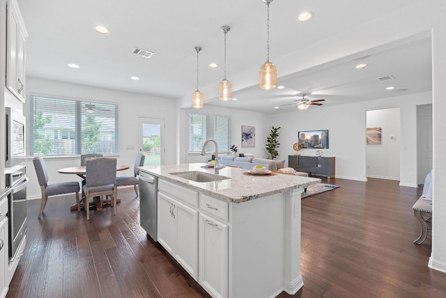 4409 Arques Ave, Round Rock, TX 78681 - kitchen with stainless steel appliances, dark wood-type flooring, recessed lighting, white cabinets, and light stone countertops