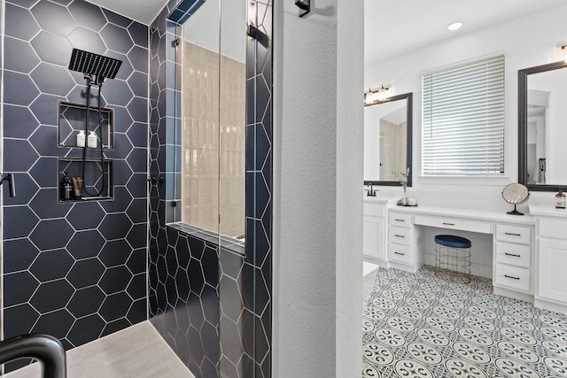 bathroom featuring a tile shower, vanity, and recessed lighting