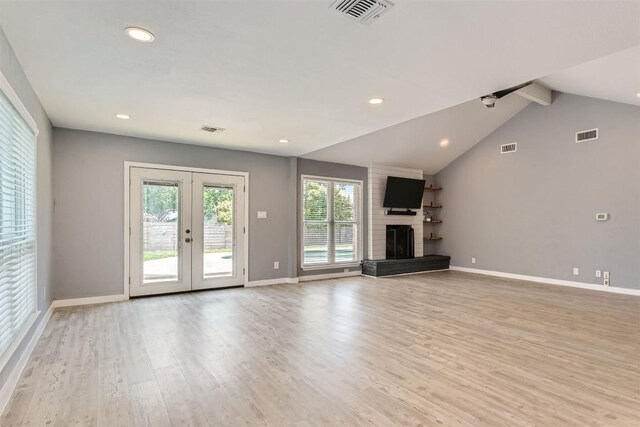 1121 Stoneoak Ln, Austin, TX 78745 - unfurnished living room with light wood-style floors, french doors, recessed lighting, and a brick fireplace