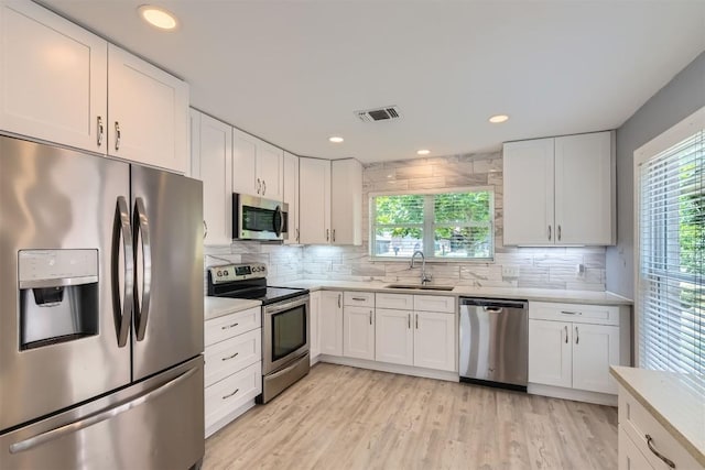 1121 Stoneoak Ln, Austin, TX 78745 - kitchen with appliances with stainless steel finishes, light countertops, tasteful backsplash, white cabinetry, and recessed lighting