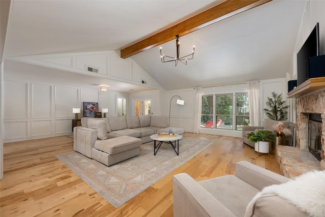 6317 Gato Path, Austin, TX 78731 - living room featuring a decorative wall, a chandelier, beam ceiling, a fireplace with raised hearth, and light wood-type flooring