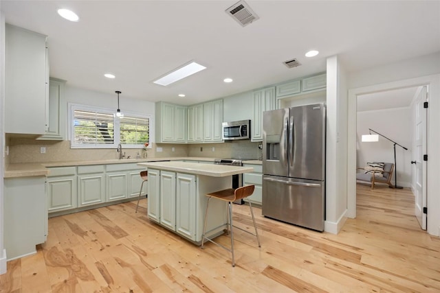 6317 Gato Path, Austin, TX 78731 - kitchen featuring appliances with stainless steel finishes, light countertops, tasteful backsplash, light wood-type flooring, and recessed lighting