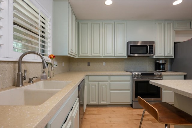 6317 Gato Path, Austin, TX 78731 - kitchen with stainless steel appliances, backsplash, light countertops, recessed lighting, and light wood finished floors