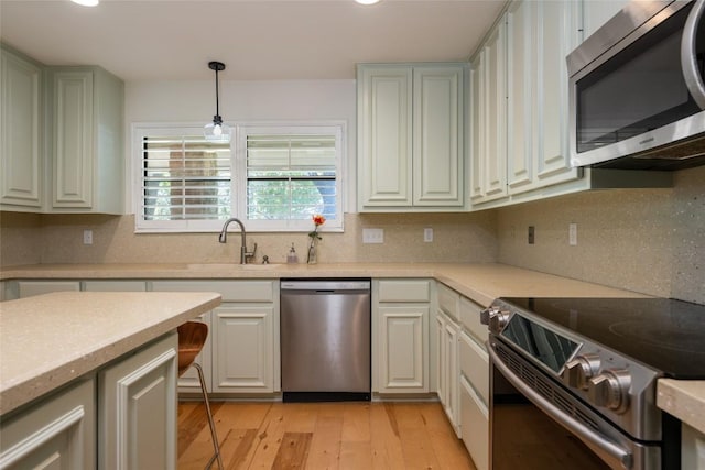 6317 Gato Path, Austin, TX 78731 - kitchen featuring stainless steel appliances, light wood-type flooring, light countertops, decorative backsplash, and decorative light fixtures