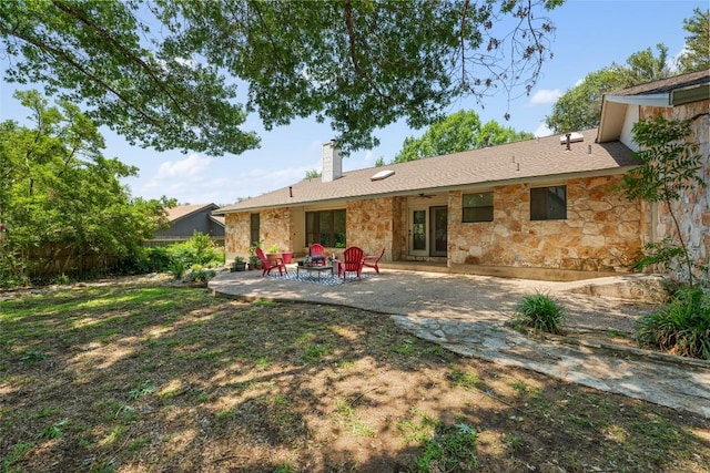 6317 Gato Path, Austin, TX 78731 - back of house featuring stone siding, a chimney, a patio, and a fire pit