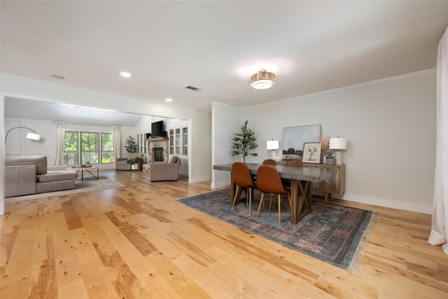6317 Gato Path, Austin, TX 78731 - dining space featuring wood finished floors, a fireplace, recessed lighting, and crown molding