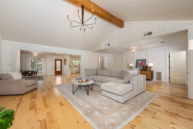 6317 Gato Path, Austin, TX 78731 - living area featuring a decorative wall, beamed ceiling, light wood finished floors, a chandelier, and high vaulted ceiling