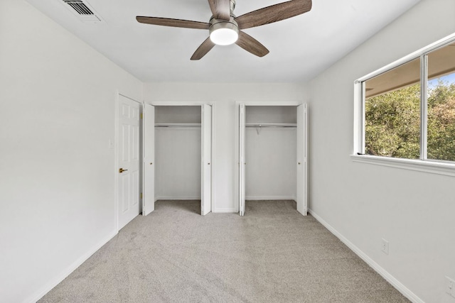 4217 Greystone Dr N, Austin, TX 78731 - unfurnished bedroom featuring multiple closets, carpet flooring, and a ceiling fan
