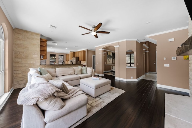 11606 Uplands Ridge Dr, Bee Cave, TX 78738 - living room with ceiling fan, arched walkways, dark wood finished floors, decorative columns, and ornamental molding