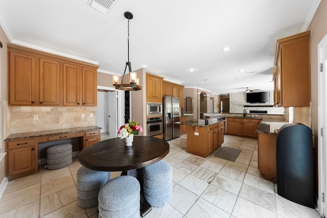 11606 Uplands Ridge Dr, Bee Cave, TX 78738 - kitchen with appliances with stainless steel finishes, backsplash, brown cabinetry, ornamental molding, and hanging light fixtures