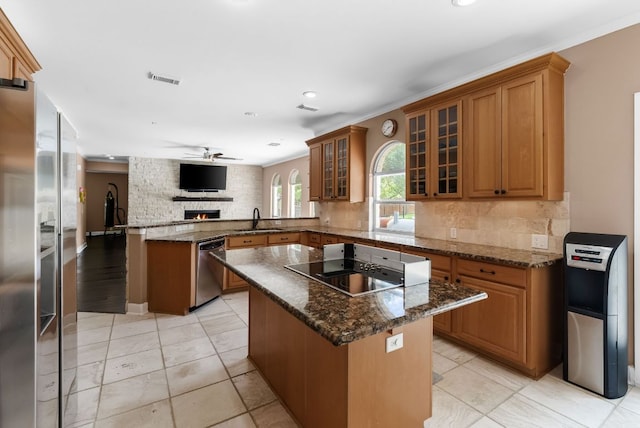 11606 Uplands Ridge Dr, Bee Cave, TX 78738 - kitchen featuring appliances with stainless steel finishes, a peninsula, brown cabinets, a ceiling fan, and a center island