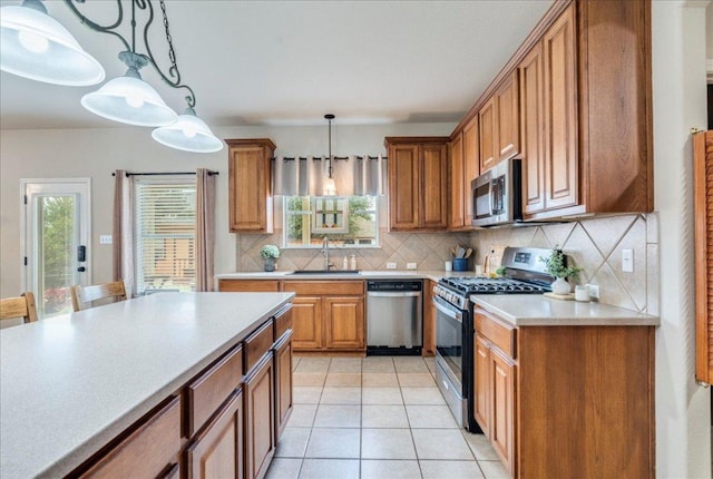 18717 Shoreless Dr, Pflugerville, TX 78660 - kitchen featuring appliances with stainless steel finishes, brown cabinets, backsplash, and decorative light fixtures