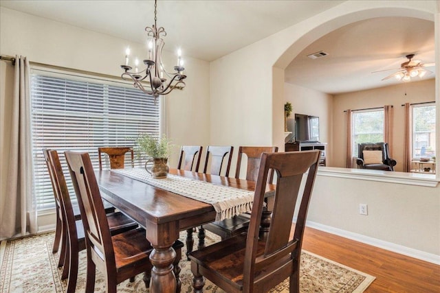 18717 Shoreless Dr, Pflugerville, TX 78660 - dining area featuring arched walkways, wood finished floors, a ceiling fan, and a chandelier