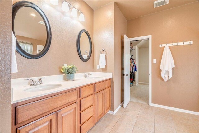 18717 Shoreless Dr, Pflugerville, TX 78660 - bathroom featuring tile patterned floors, double vanity, and a walk in closet