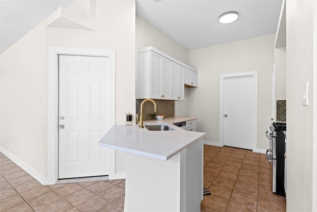 12922 Staton Dr, Austin, TX 78727 - kitchen featuring stainless steel gas stove, tasteful backsplash, white cabinets, light countertops, and a peninsula