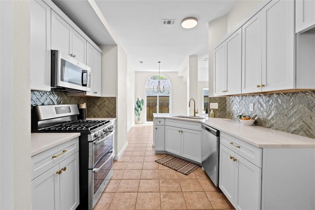 12922 Staton Dr, Austin, TX 78727 - kitchen with stainless steel appliances, decorative backsplash, white cabinets, and light tile patterned floors