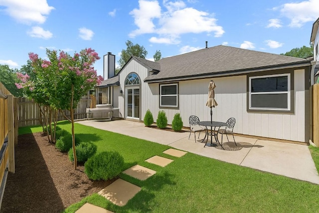 12922 Staton Dr, Austin, TX 78727 - back of house featuring a fenced backyard, a patio area, a shingled roof, and a chimney