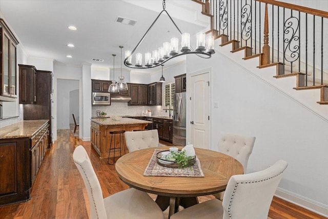 13212 Coleto Creek Trl, Austin, TX 78732 - dining space featuring wood finished floors, stairs, recessed lighting, a chandelier, and crown molding