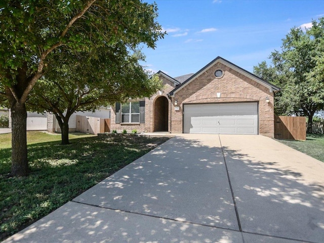 241 Sunnyside Dr, Kyle, TX 78640 - view of front of house featuring driveway, an attached garage, and brick siding