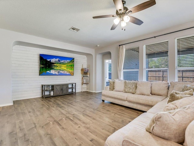 241 Sunnyside Dr, Kyle, TX 78640 - living area with arched walkways, healthy amount of natural light, ceiling fan, and wood finished floors