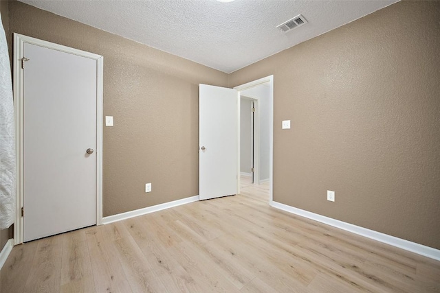 1009 Laurelleaf Dr, Pflugerville, TX 78660 - empty room with a textured wall, wood finished floors, and a textured ceiling