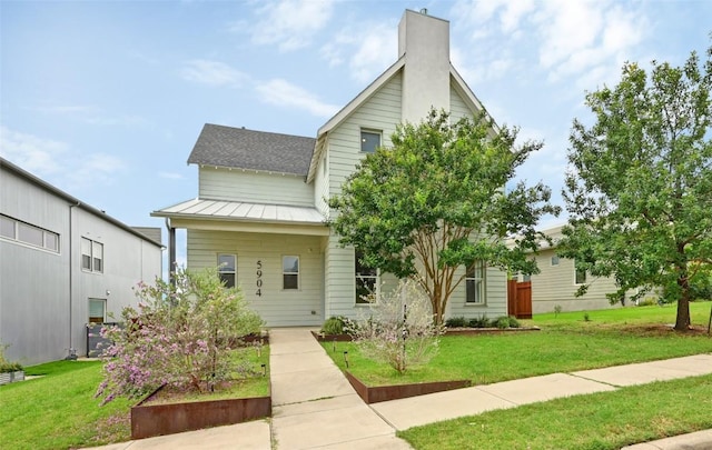5904 Florencia Ln, Austin, TX 78724 - view of front of property with a standing seam roof, a front yard, a metal roof, and a chimney