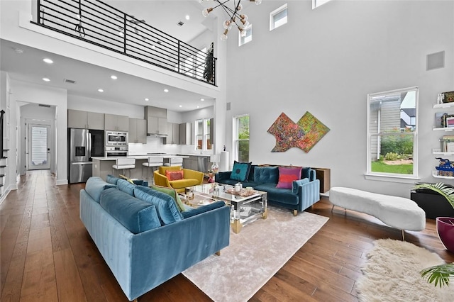 5904 Florencia Ln, Austin, TX 78724 - living area featuring a high ceiling, a chandelier, dark wood-style flooring, and recessed lighting