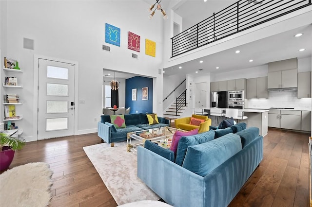5904 Florencia Ln, Austin, TX 78724 - living area with a high ceiling, stairs, dark wood finished floors, a chandelier, and recessed lighting
