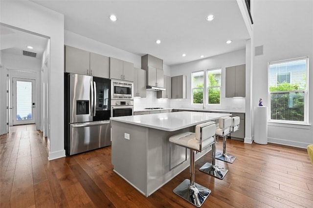 5904 Florencia Ln, Austin, TX 78724 - kitchen with stainless steel appliances, gray cabinets, a center island, a breakfast bar area, and light countertops