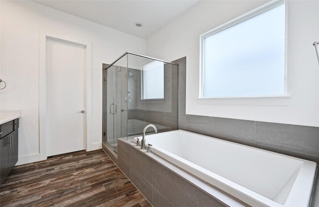 5904 Florencia Ln, Austin, TX 78724 - bathroom with a bath, vanity, a stall shower, and wood finished floors