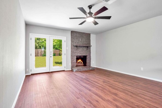 606 Elderberry Cv, Austin, TX 78745 - unfurnished living room featuring french doors, wood finished floors, a ceiling fan, and a fireplace