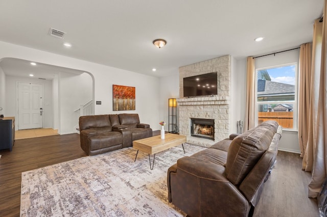 716 Madalin Rue Ct, Leander, TX 78641 - living room with a fireplace, wood finished floors, arched walkways, and recessed lighting