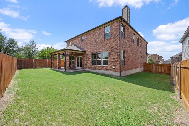 716 Madalin Rue Ct, Leander, TX 78641 - back of property featuring brick siding, a chimney, and a fenced backyard