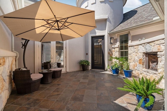 2105 Peoria Dr, Leander, TX 78641 - property entrance featuring stone siding, stucco siding, roof with shingles, french doors, and a patio area