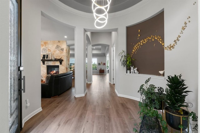 2105 Peoria Dr, Leander, TX 78641 - hall featuring arched walkways, wood finished floors, crown molding, and a chandelier