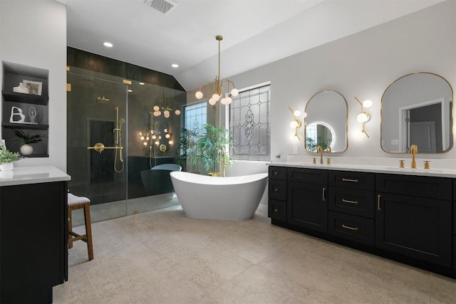 2105 Peoria Dr, Leander, TX 78641 - full bath featuring double vanity, an enclosed shower, a soaking tub, lofted ceiling, and a chandelier
